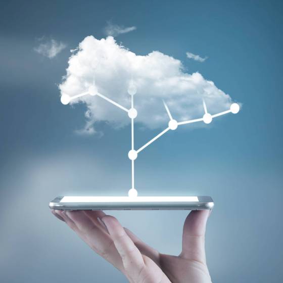 Hand holding a smartphone with a circuit board tree and a cloud above Hand holding a smartphone with a circuit board tree and a cloud above